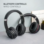 Two black over-ear headphones, one with Bluetooth functionality and the other wired, placed on a light gray surface.