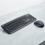 Black wireless keyboard and mouse placed neatly on a light gray surface, showcasing sleek design and compact functionality.